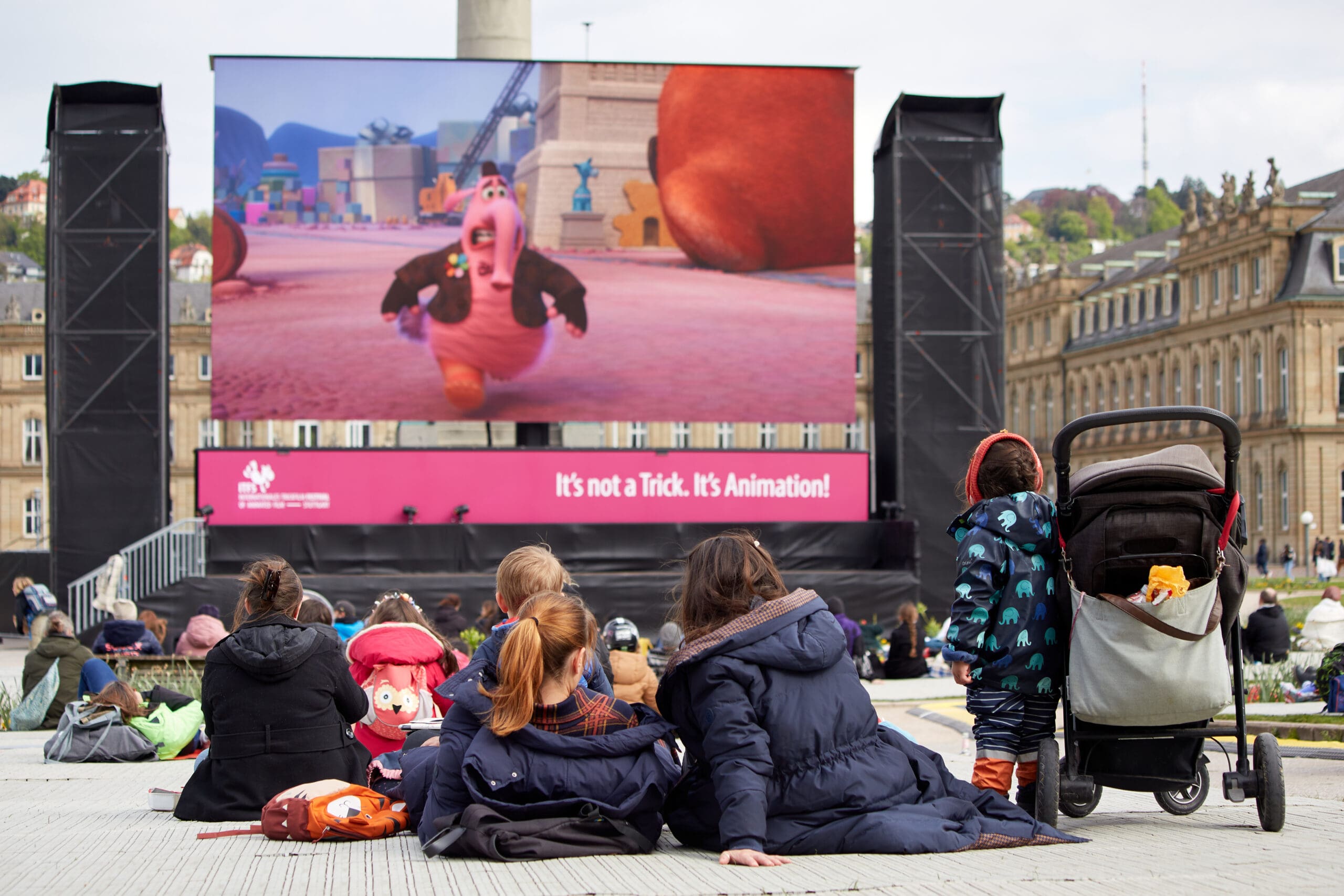 Familie sitzt vor großer Leinwand auf dem Schlossplatz
