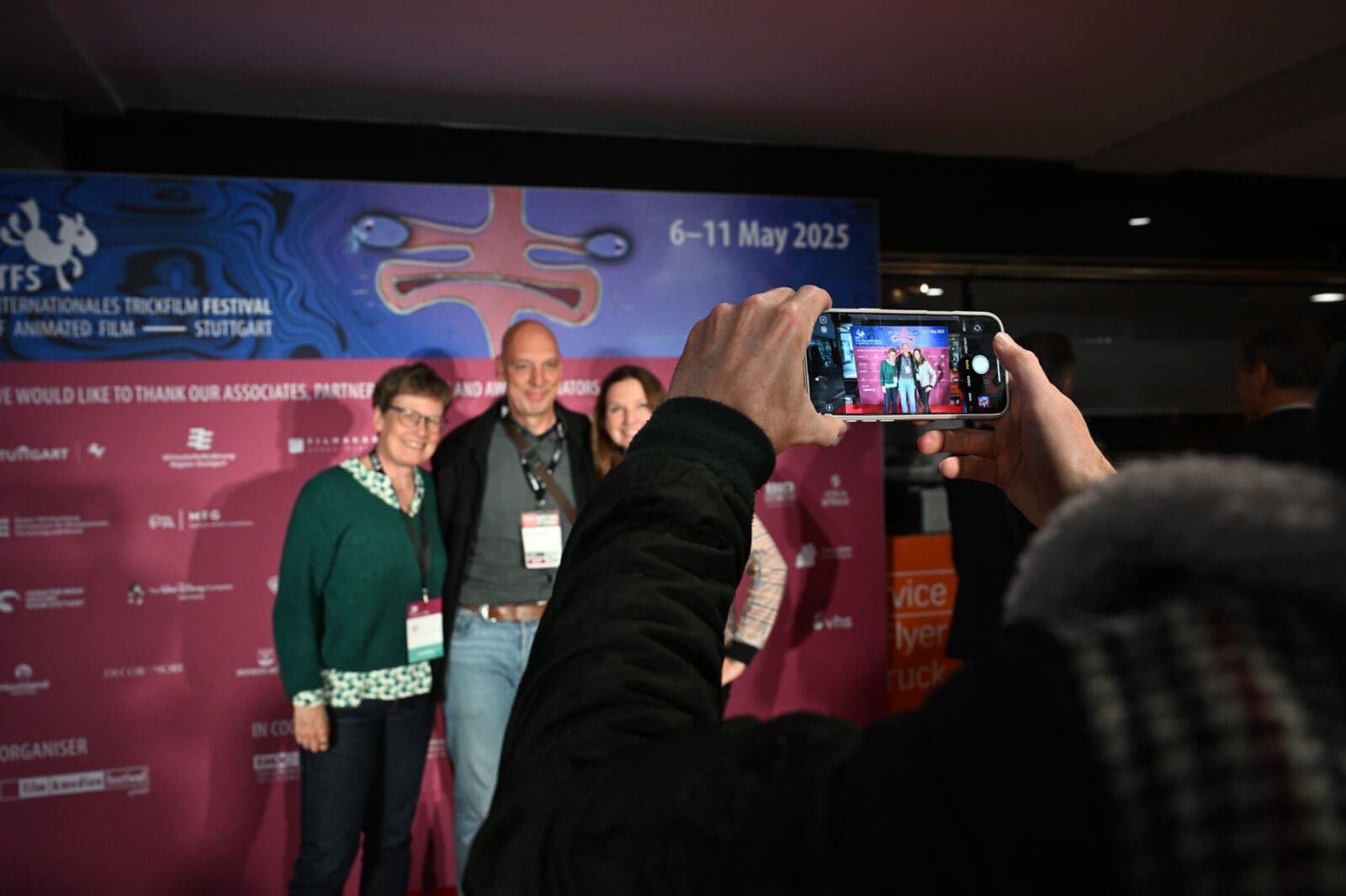 Fotos mit Handy vor der Fotowand