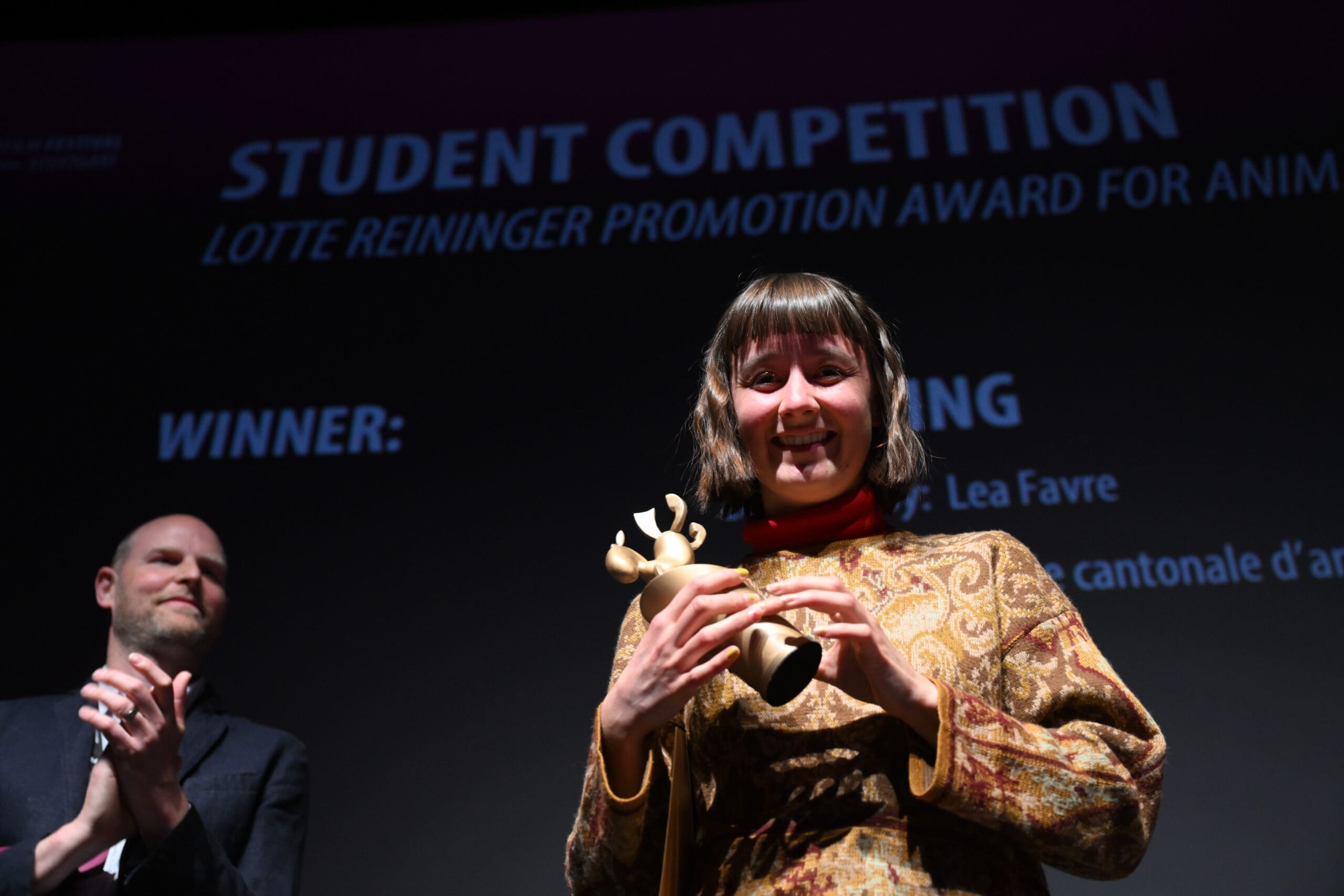 Glückliche Preisträgerin mit Statue