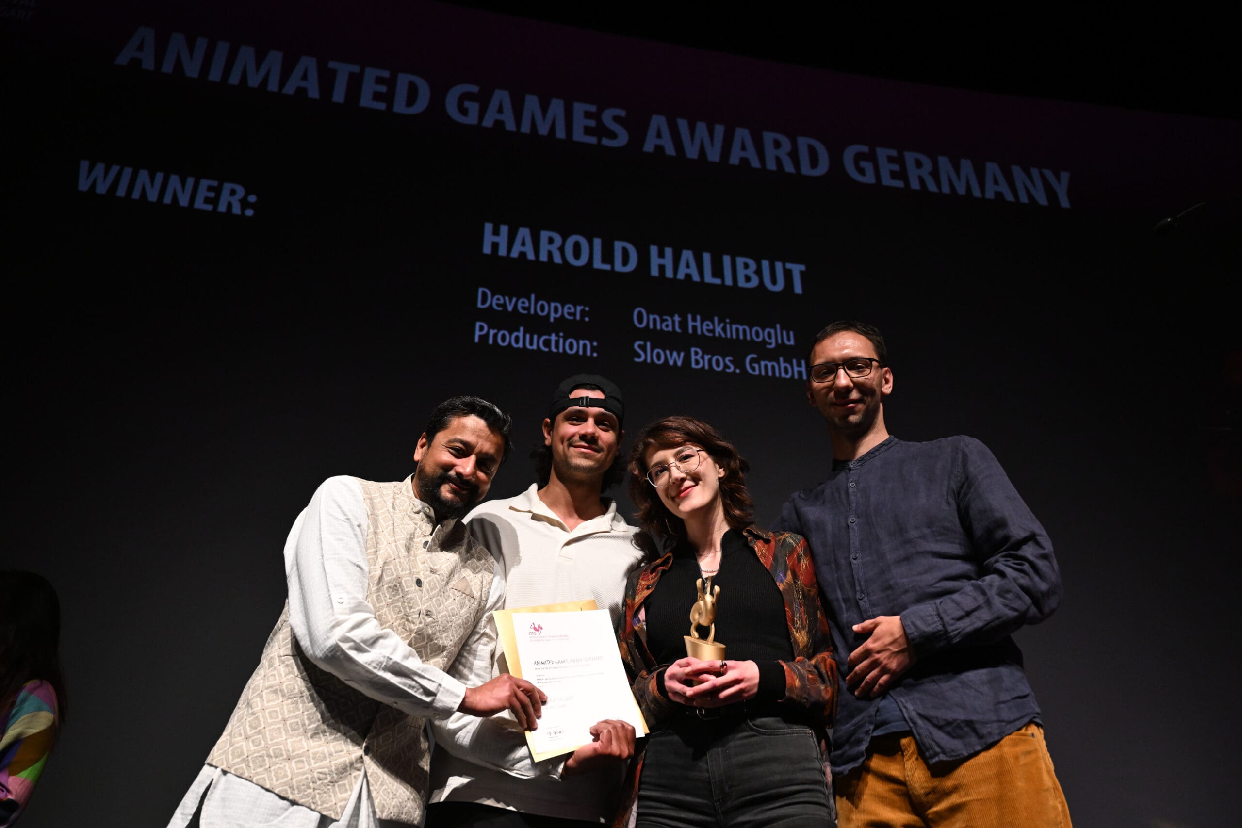 Die Gewinner des Games Awards auf der Bühne mit Urkunde und Preis